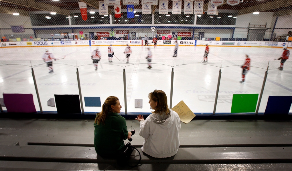 Women chat while watching players at a rink in Chestermere, Alta., in May 2012. (Jeff McIntosh / THE CANADIAN PRESS)