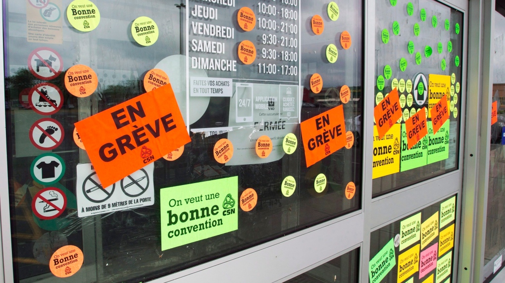 Stickers cover the entrance to an SAQ outlet as liquor store employees go on strike to press lagging contract negotiations, Tuesday, July 17, 2018 in St. Marthe-sur-le-Lac Que.THE CANADIAN PRESS/Ryan Remiorz 