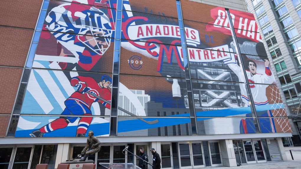 People walk past a new mural celebrating the Montreal Canadiens history outside the Bell Center, in Montreal, Friday, Nov. 19, 2021. THE CANADIAN PRESS/Ryan Remiorz 