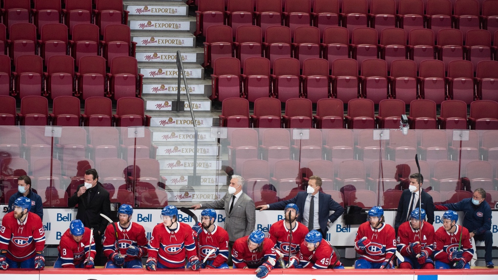 Montreal Canadiens players and coaching staff look on from the bench against a backdrop of empty seats during during second period NHL hockey action against the Philadelphia Flyers in Montreal, Thursday, December 16, 2021. THE CANADIAN PRESS/Graham Hughes 