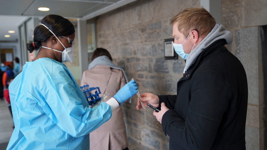 A nurse hands out a swab for a COVID-19 rapid self test at a test clinic in Montreal, on Wednesday, December 15, 2021. THE CANADIAN PRESS/Paul Chiasson 