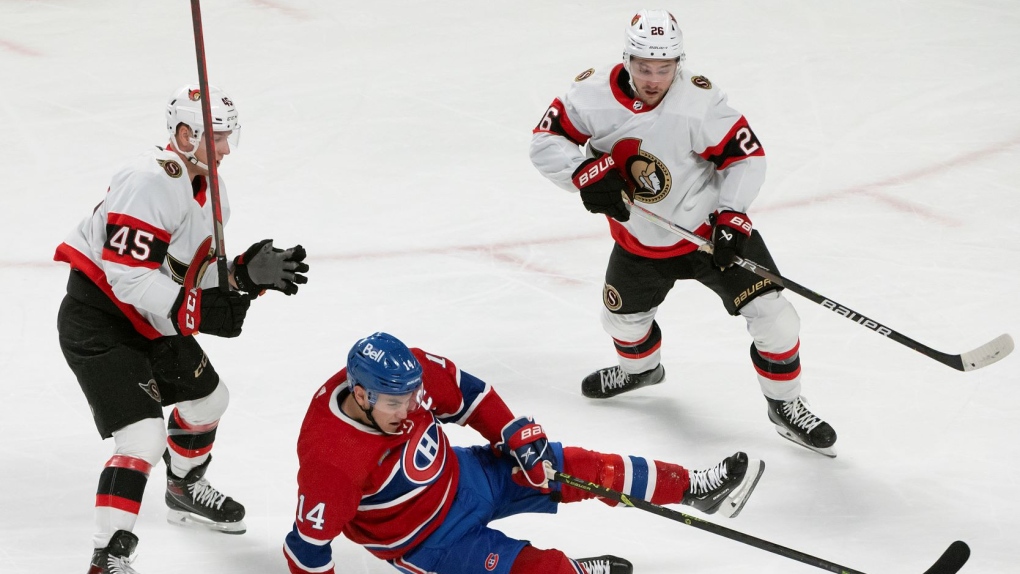 Montreal Canadiens Nick Suzuki (14) looses control as he tries to take the puck between Ottawa Senators Parker Kelly (45) and Erik Brannstrom (26) during second period NHL hockey action in Montreal, Tuesday, Oct. 4, 2022. THE CANADIAN PRESS/Peter McCabe