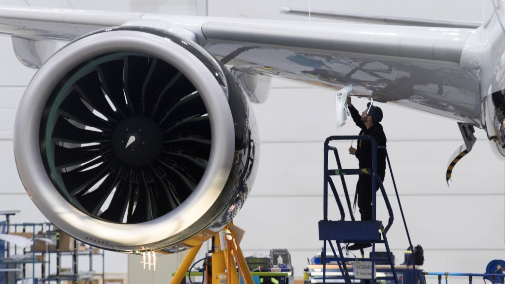 An Airbus employee works under the wing of an Airbus A220 at the assembly plant in Mirabel, Que., Thursday, February 20, 2020. THE CANADIAN PRESS/Graham Hughes