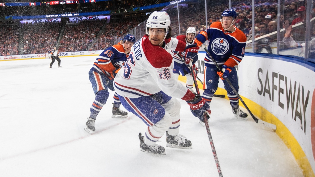 Montreal Canadiens' Johnathan Kovacevic (26) battles for the puck with Edmonton Oilers' Dylan Holloway (55) and Tyler Benson (16) during second period NHL action in Edmonton on Saturday, December 3, 2022.THE CANADIAN PRESS/Jason Franson