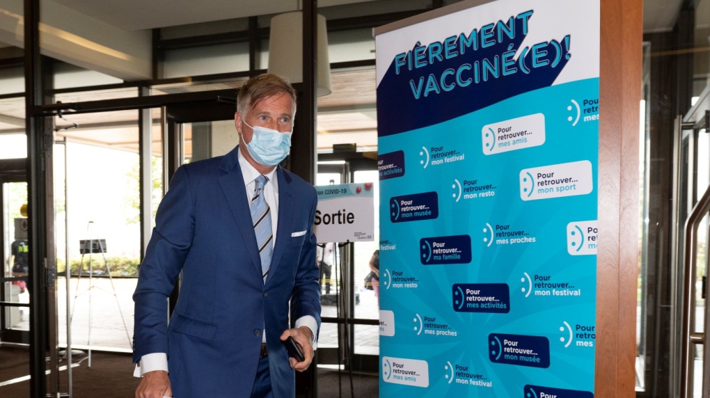 People's Party of Canada Leader Maxime Bernier walks by a sign that says "proud to be vaccinated" as he arrives a hotel, which is also a vaccination site, to launch his campaign in Saint-Georges, Que., Friday, Aug. 20, 2021. THE CANADIAN PRESS/Jacques Boissinot