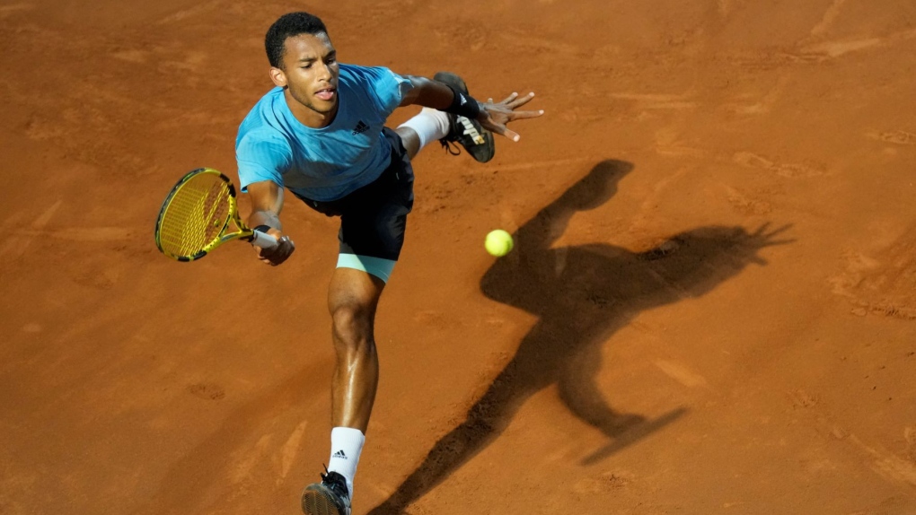 Felix Auger-Aliassime of Canada returns the ball to Novak Djokovic of Serbia during their match at the Italian Open tennis tournament, in Rome, Friday, May 13, 2022. (AP Photo/Andrew Medichini)