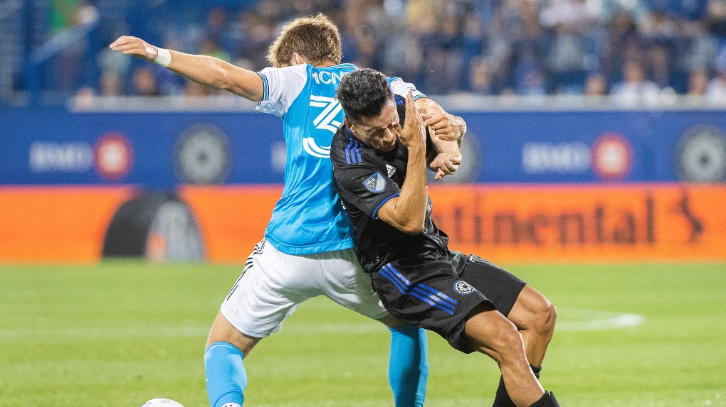 CF Montreal midfielder Joaquin Torres, right, is challenged by Charlotte FC's Quinn McNeill during second half MLS soccer action in Montreal, Saturday, June 25, 2022. THE CANADIAN PRESS/Graham Hughes