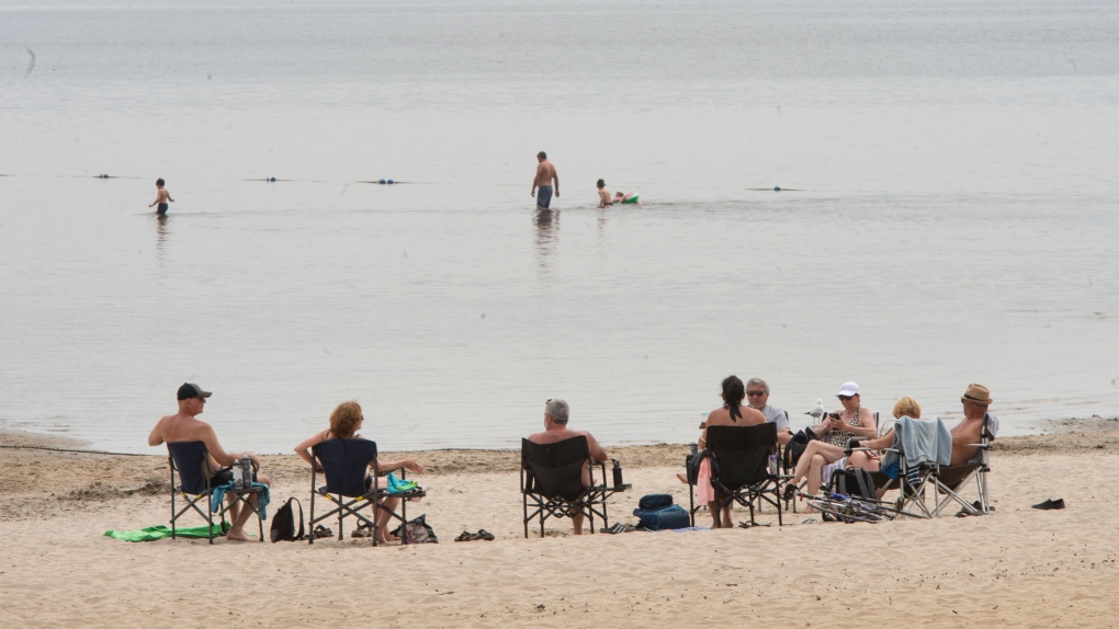 People enjoy the warm weather at the beach in Oka Provincial Park. (THE CANADIAN PRESS/Ryan Remiorz)