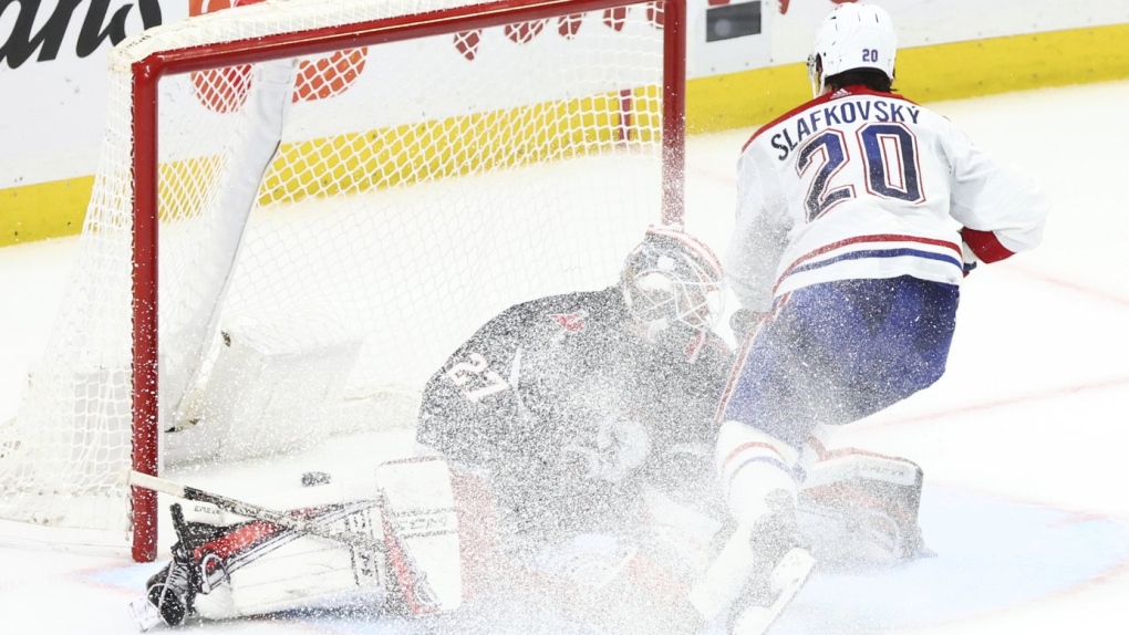 Montreal Canadiens left wing Juraj Slafkovsky (20) scores on Buffalo Sabres goaltender Devon Levi (27) during the shootout in an NHL hockey game Saturday, Dec. 9, 2023, in Buffalo, N.Y. (AP Photo/Jeffrey T. Barnes)