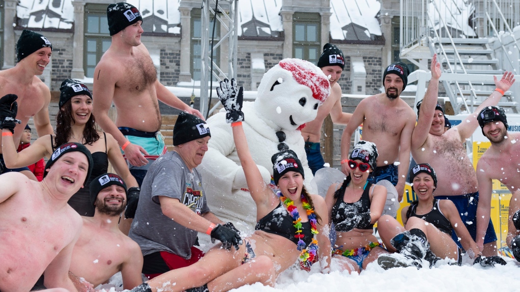 Snow bathers play in the snow with Bonhomme as part of Quebec's winter carnival activities, in Quebec City, Sunday, Feb. 16, 2020. THE CANADIAN PRESS/Jacques Boissinot