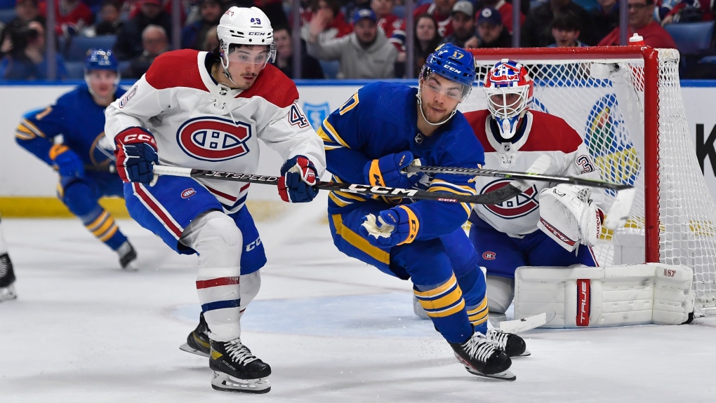 Montreal Canadiens left wing Rafael Harvey-Pinard, left, and Buffalo Sabres center Tyson Jost chase the puck during the second period of an NHL hockey game in Buffalo, N.Y., Monday, March 27, 2023. (AP Photo/Adrian Kraus)