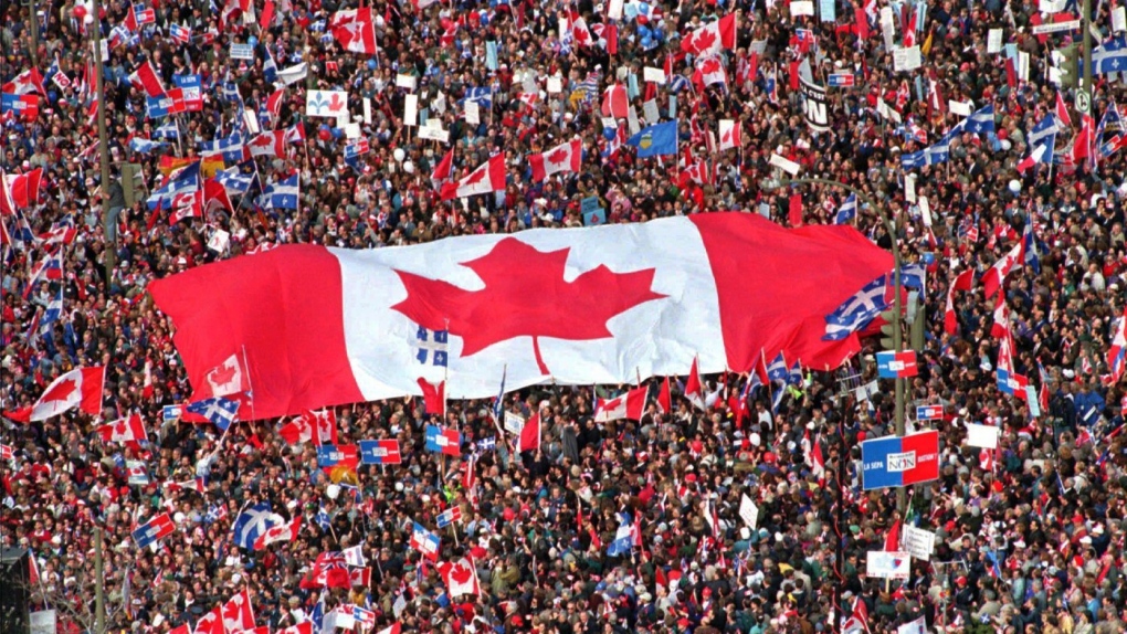 A large Canadian flag is passed through a crowd in as thousands from all over Canada join Quebecers rallying for national unity three days before a referendum that could propel Quebec toward secession, in Montreal on October 27, 1995. THE CANADIAN PRESS/Ryan Remiorz