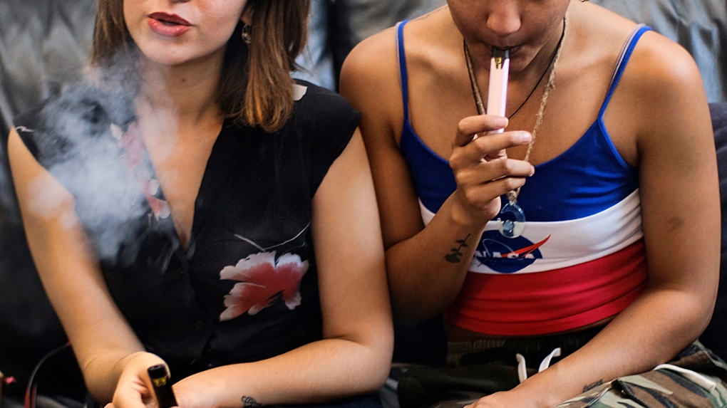  In this Saturday, June 8, 2019, file photo, two women smoke cannabis vape pens at a party in Los Angeles. (AP Photo/Richard Vogel, File) Montreal police arrest a man allegedly at the head of a network that distributed vaping products to teenagers.