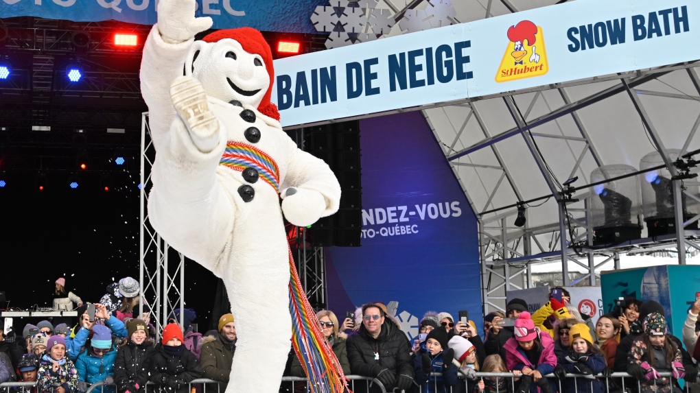 Bonhomme Carnaval raises his leg and celebrates at the annual Quebec Winter Carnival snow bath, Sunday, February 12, 2023 in Quebec City. THE CANADIAN PRESS/Jacques Boissinot