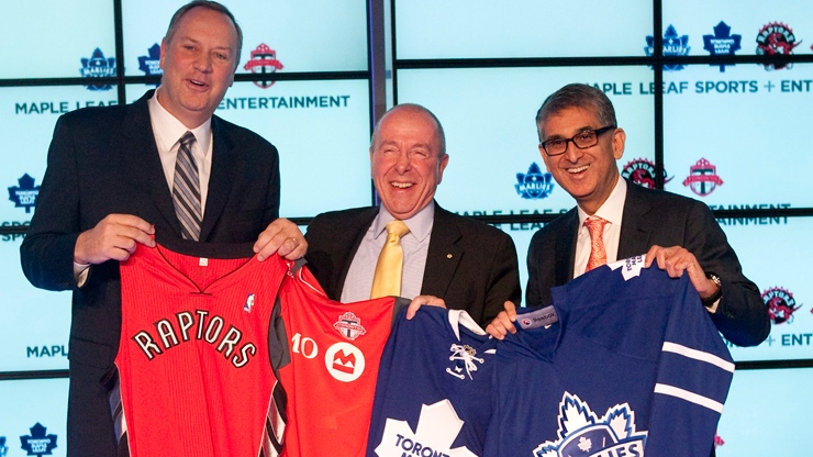 George Cope, president and CEO of Bell (left), MLSE Chairman Larry Tanenbaum (centre) and Nadir Mohamed, president and CEO of Rogers hold up Toronto Raptors, Toronto FC, Toronto Maple Leafs and Toronto Marlies jerseys following a press conference in Toronto on Friday, Dec. 9, 2011. (Chris Young / THE CANADIAN PRESS)