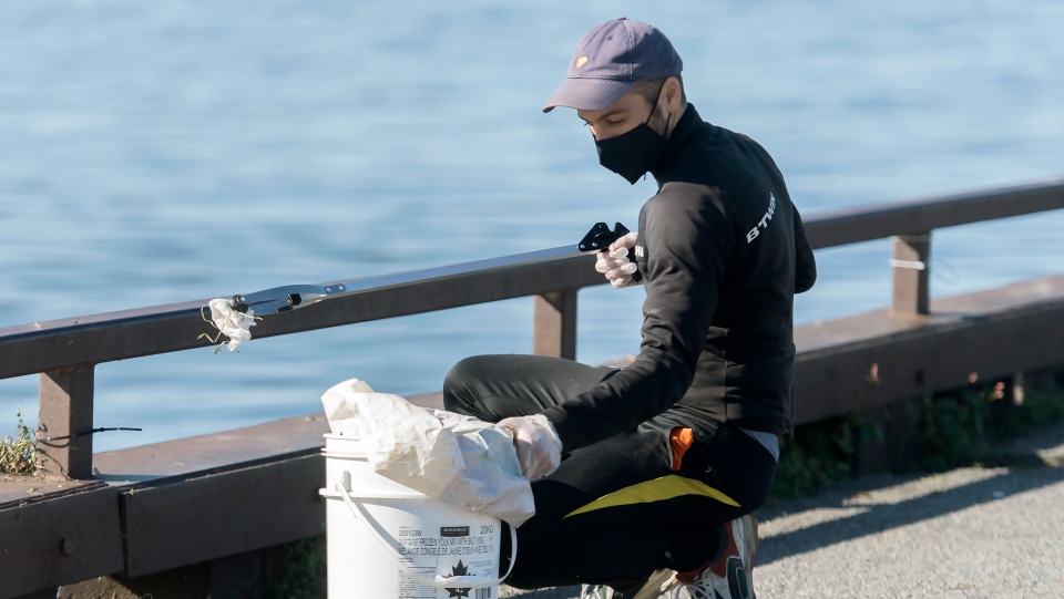 A man picking up trash from the St. Lawrence