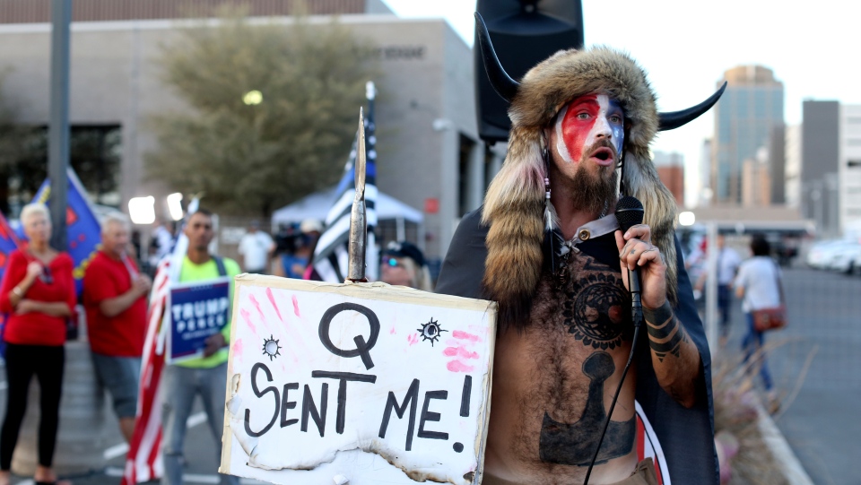 A Qanon believer speaks to a crowd