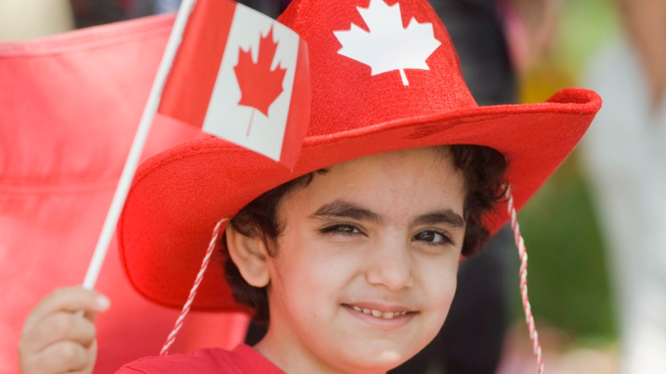 Young boy waves the national flag on Canada Day