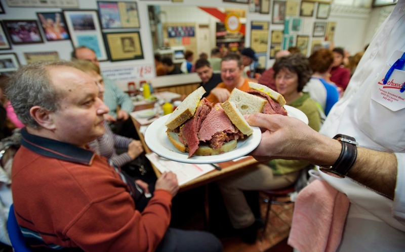 A waiter serves up smoked meat sandwiches at Schwartz's deli in Montreal
